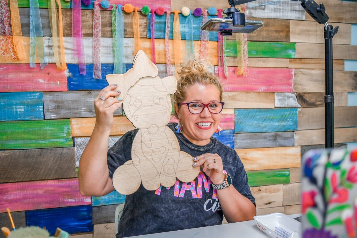 Tamara holding a blank wood baby cow door hanger