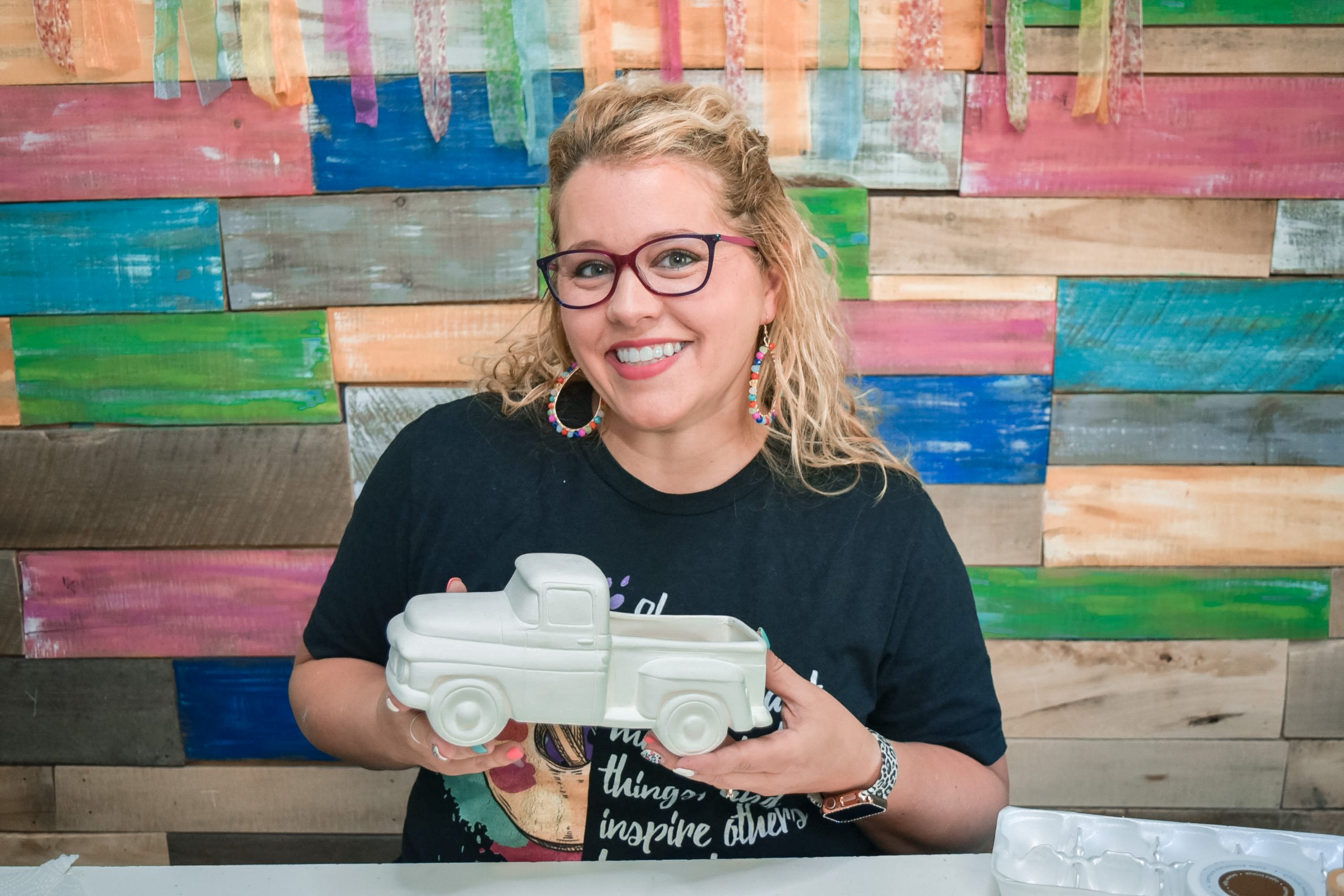 Tamara Bennett holding a white unpainted ceramic truck