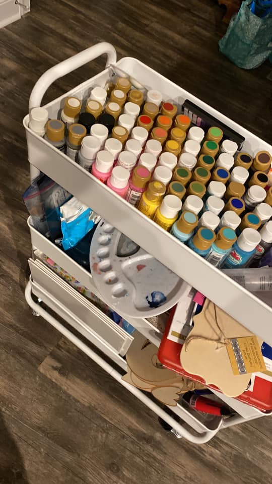 Rolling cart with paint bottles and paint supplies