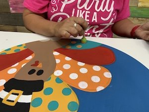 using a sponge pouncer to add polka dots to the turkey feathers