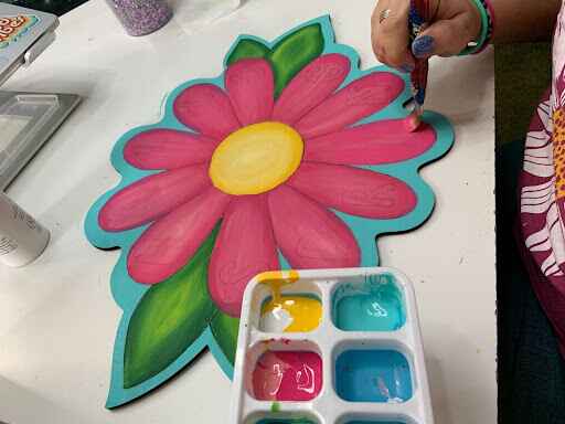 Close up of Tamara painting the daisy flower door hanger