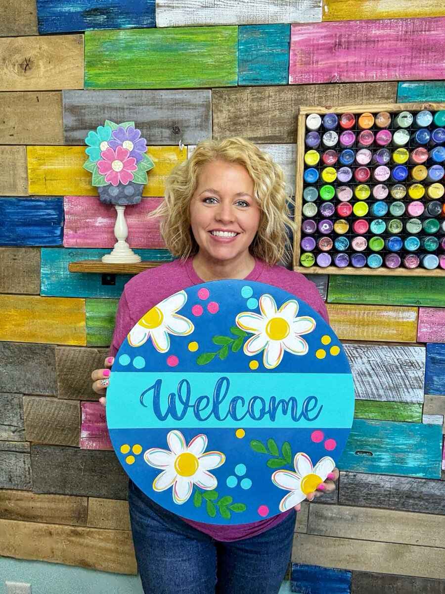 Tamara holding welcome sign with flowers