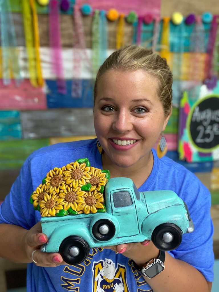 Tamara holding ceramic truck with sunflowers