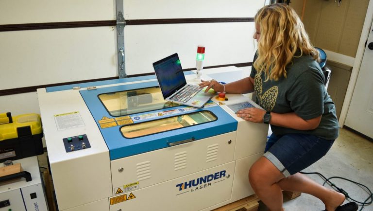 Tamara using a computer to send a design to the Thunder Laser Machine.